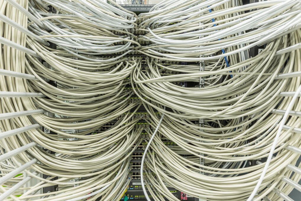 Dicht gepackte weiße Kabel in einem Netzwerk-Server-Schrank.